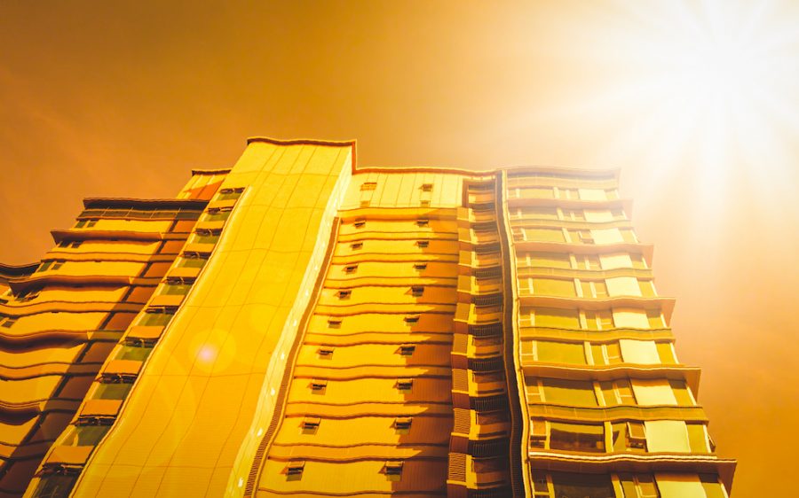 Picture of a hazy, golden, apartment building. It is meant to make a person feel hot and dizzy, like if they were suffering from heat exhaustion.